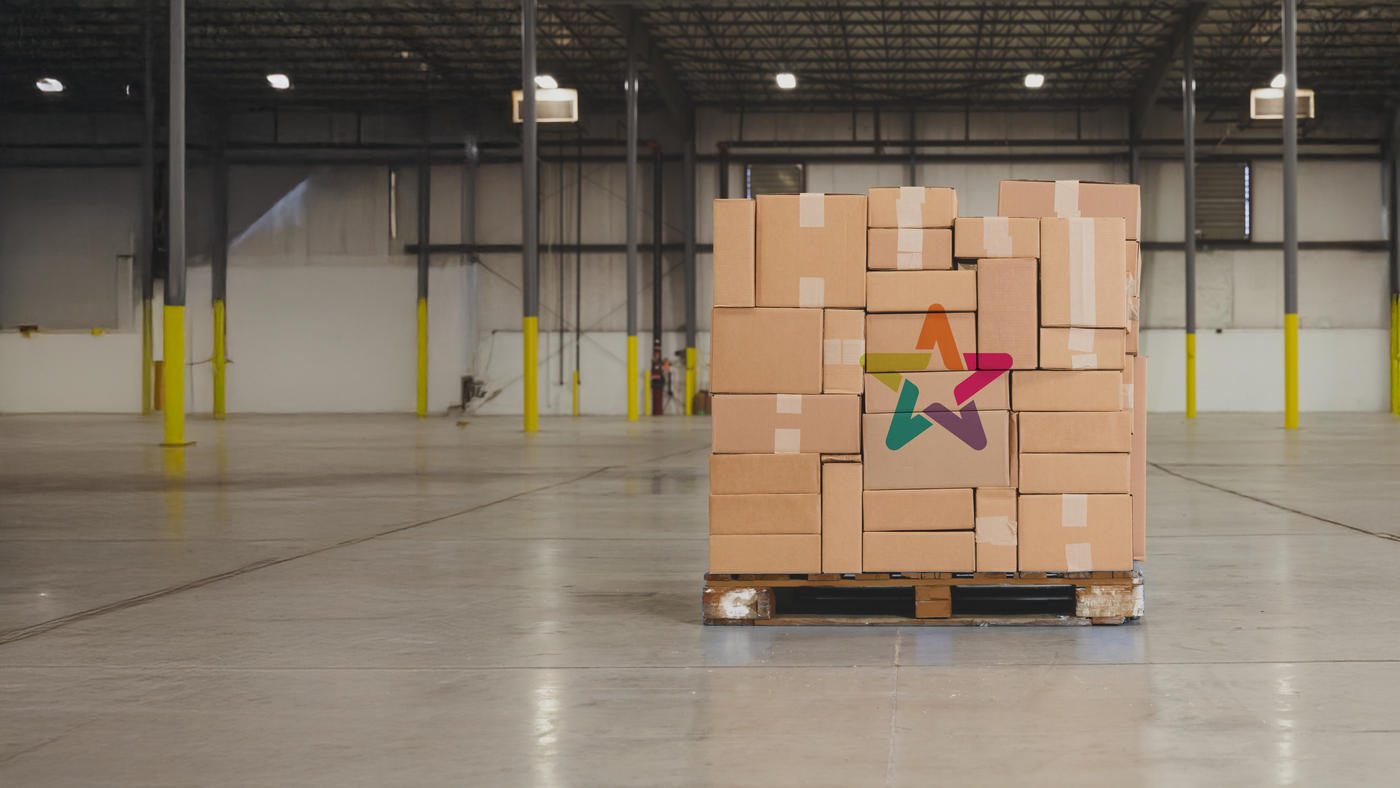 Pallet of cardboard boxes with Big Star Lights logo in a warehouse.
